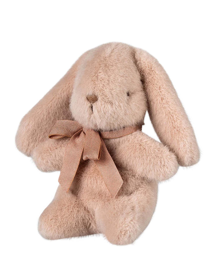 The "mini bunny plush in light powder" by Maileg is crafted from soft polyester fabric, featuring a simple expression and adorned with a brown bow.
