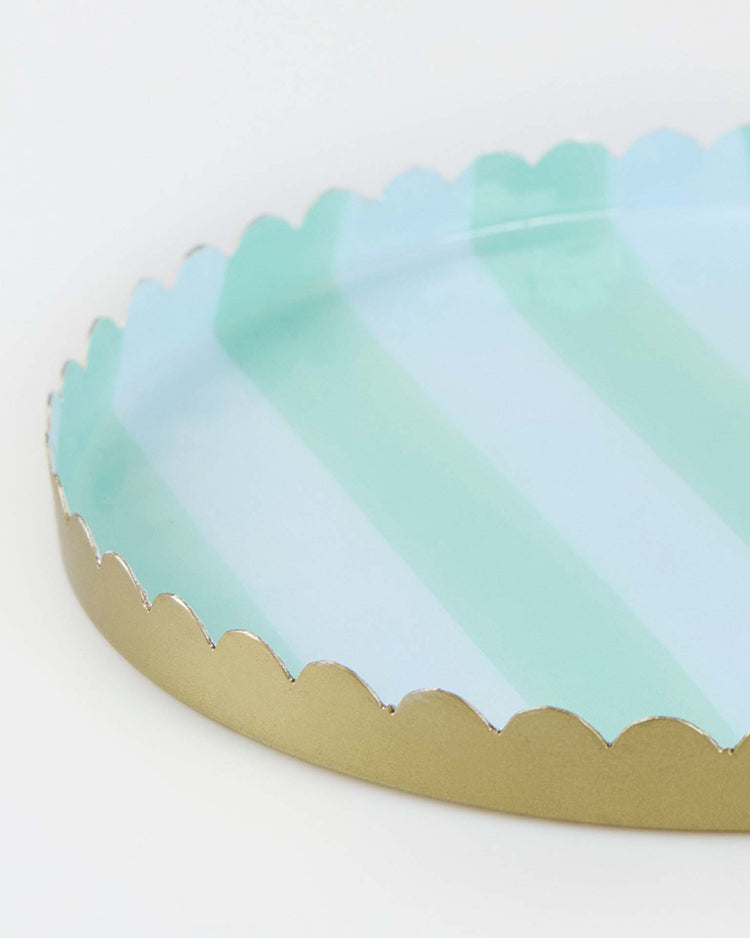 A close-up of the meri meri pastel striped small accessory tray, featuring light blue and mint green vertical stripes, a scalloped gold edge, and a glossy enamel finish.