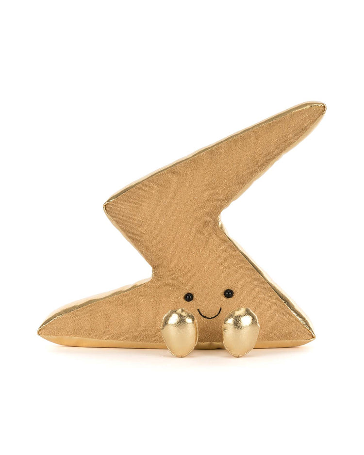 The Jellycat Amuseables Zapperty Lightning Bolt is a gold plush toy shaped like a lightning bolt, with a smiling face and two small gold feet, shown on a white background.