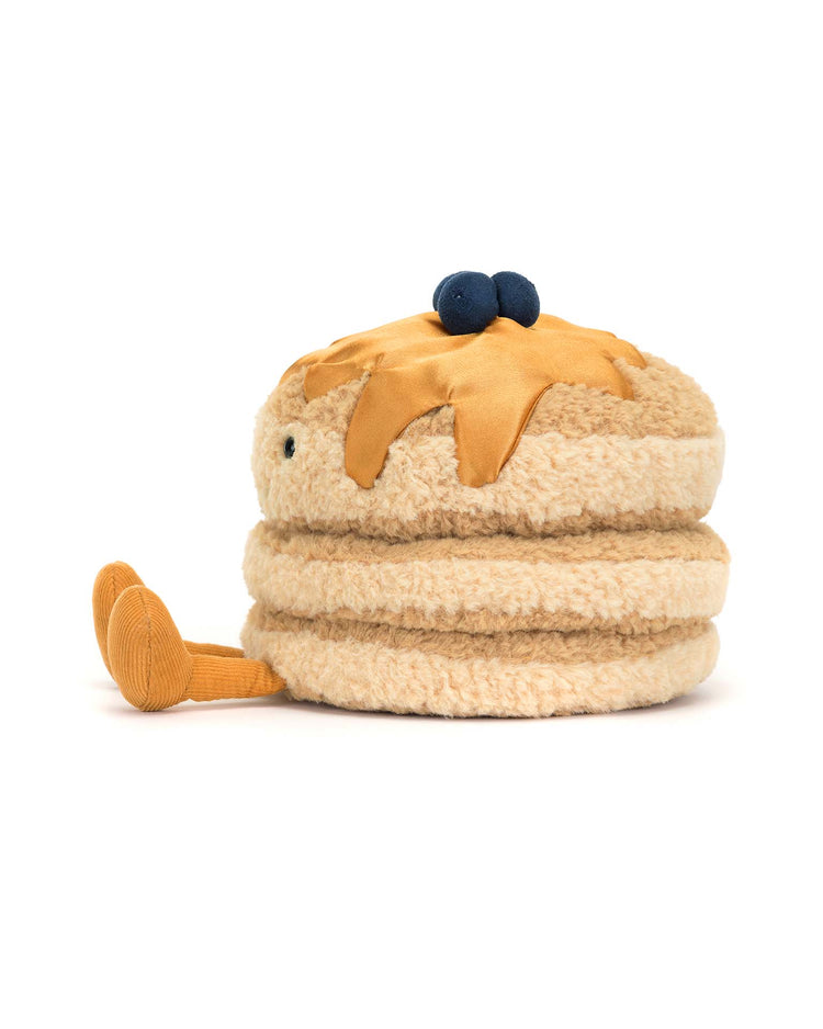 Meet Jellycats Amuseables Fran Pancakes, a charming stuffed toy stack of pancakes with syrup and textured blueberries, featuring fluffy golden fur, cute legs, and eyes. Its an ideal whimsical companion for anyone fond of breakfast-themed fun!.