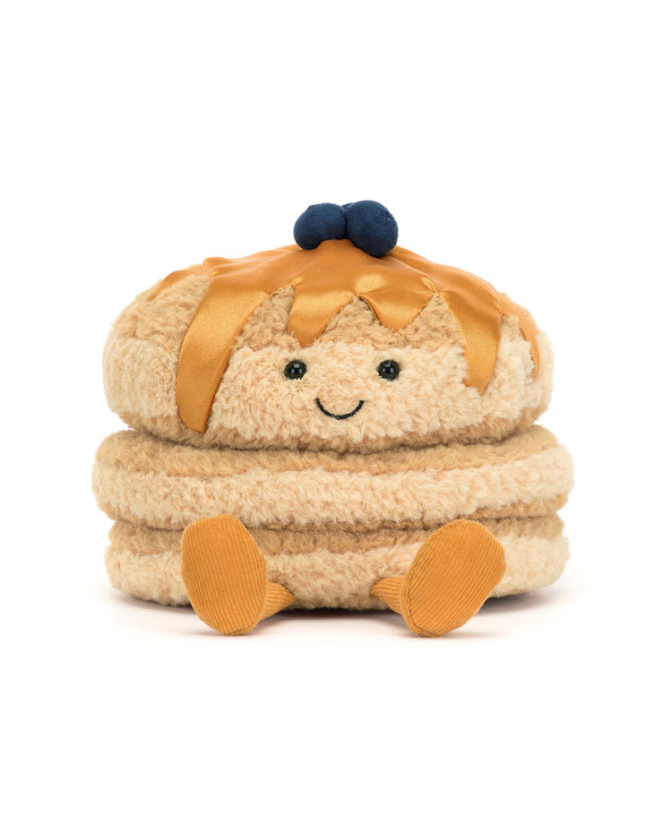 Meet Jellycats Amuseables Fran Pancakes: a charming plush stack adorned with textured blueberries and syrup, featuring fluffy golden fur and a joyful smile to brighten your day.