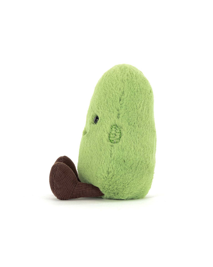 A small, plush green avocado toy with a brown pit, viewed from the side, resembles the Jellycat amuseables soyella edamame bean and is set against a plain white background.
