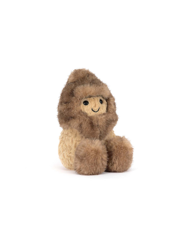 The Jellycat Amuseables Peanut Yeti Outfit is a plush toy with a round face, light brown body, and dark furry hood and mittens, sitting upright on a white background and smiling simply in its cozy forest-ready attire.