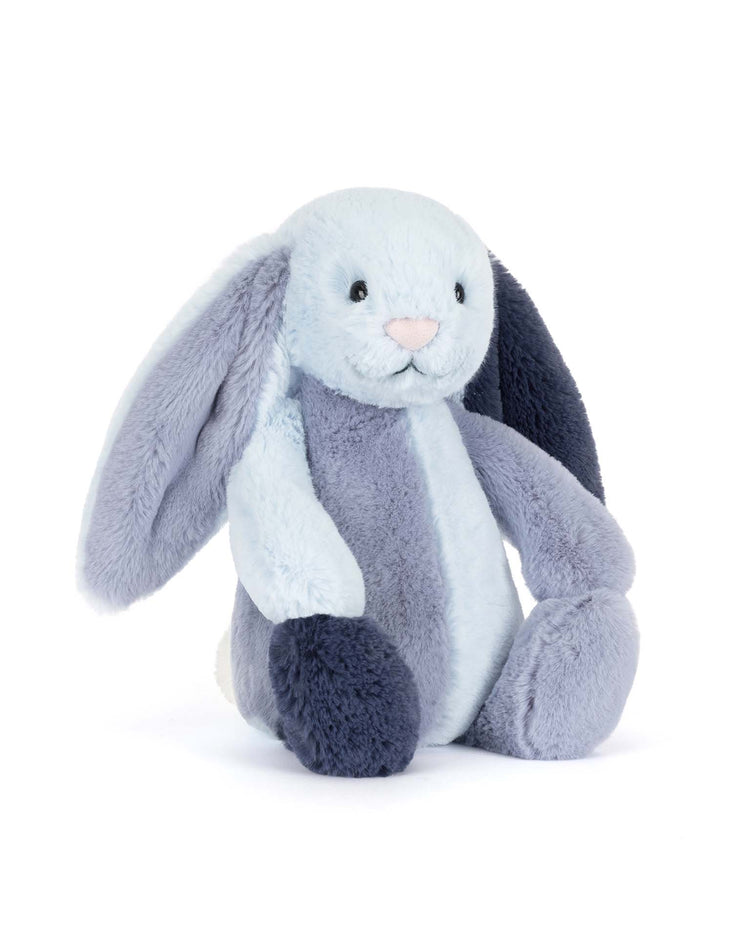 The Jellycat Puddlesea Bunny Original is a soft plush with floppy ears, light blue and dark blue fur, a small pink nose, and black button eyes. It sits upright on a white background.
