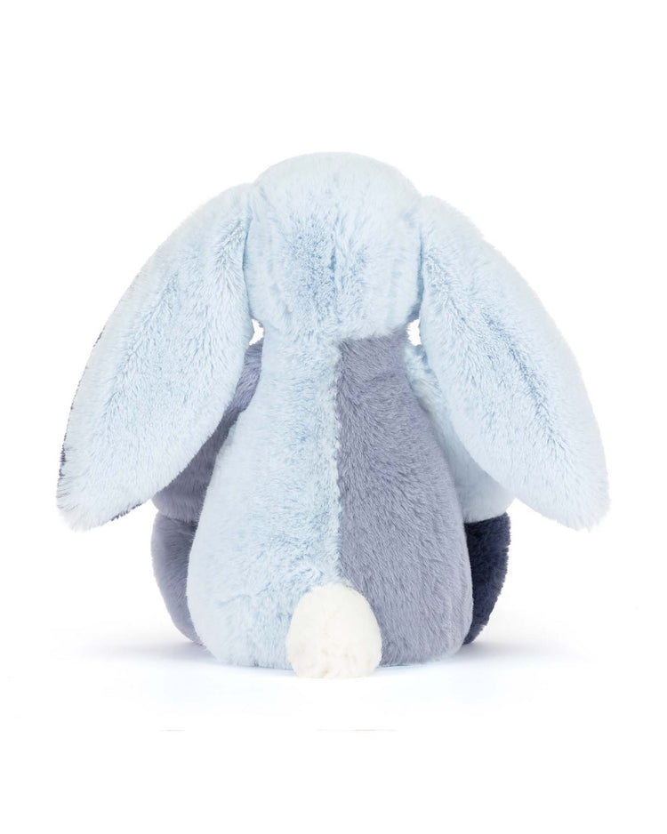 The jellycat puddlesea bunny original, a light blue plush with long floppy ears and a fluffy white tail, sits playfully posed with its back to the viewer—a charming plush or unique beach toy on a white background.