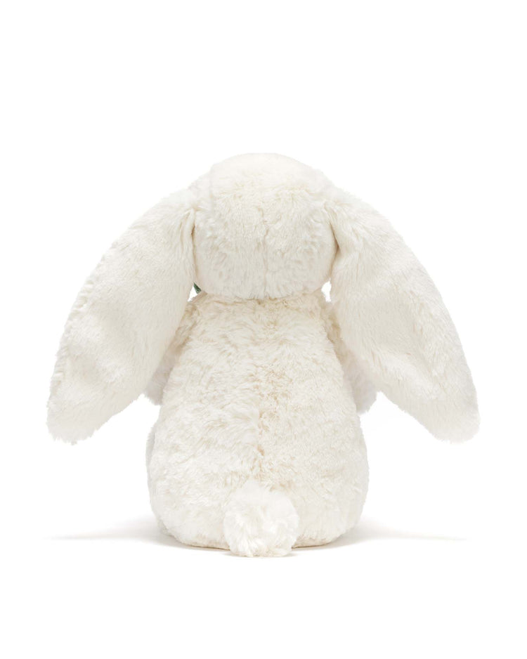 The jellycat cream bunny with plant is pictured from behind, highlighting its long floppy ears and small fluffy tail against a plain white background.