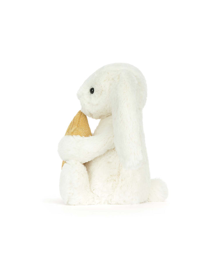 The Jellycat Cream Bunny with Star plush sits upright, holding a soft yellow ice cream cone in its paws against a plain white background—an adorable gift for milestones.