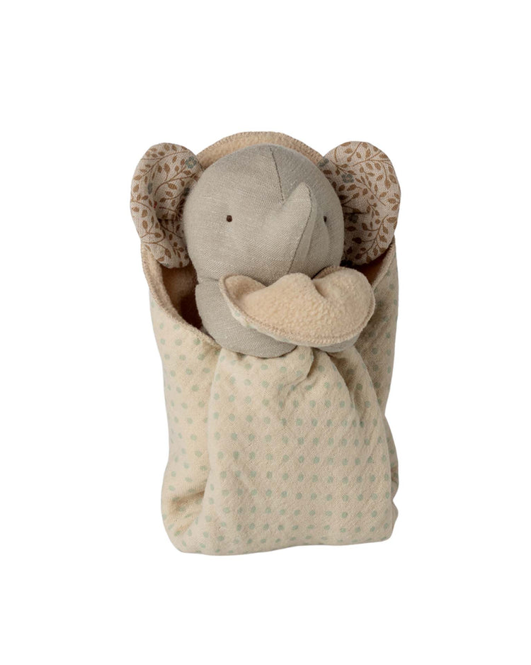 The maileg lullaby friends, elephant, mini - iron grey is a soft plush cuddle cloth featuring patterned inner ears, wrapped in a beige polka-dot blanket. This gentle neutral-colored toy is the perfect newborn gift.