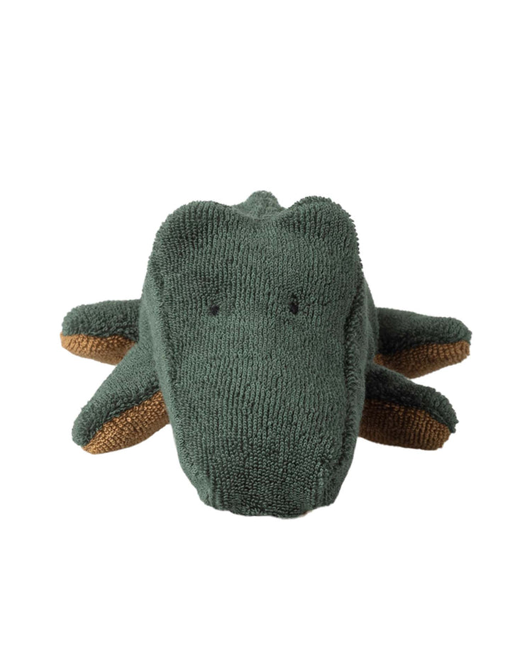The mini crocodile in forest green from maileg's safari friends line features textured fabric, small black eyes, and brown feet accents. This plush toy is a cozy companion for all ages, perfect for cuddling or display against any backdrop.