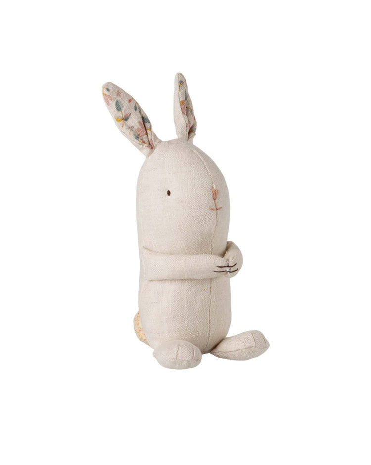 The maileg lullaby friends, bunny, mini - nature is a beige fabric soft toy with floral-patterned ears and stitched features, sitting upright with clasped arms—an adorable gift for babies.
