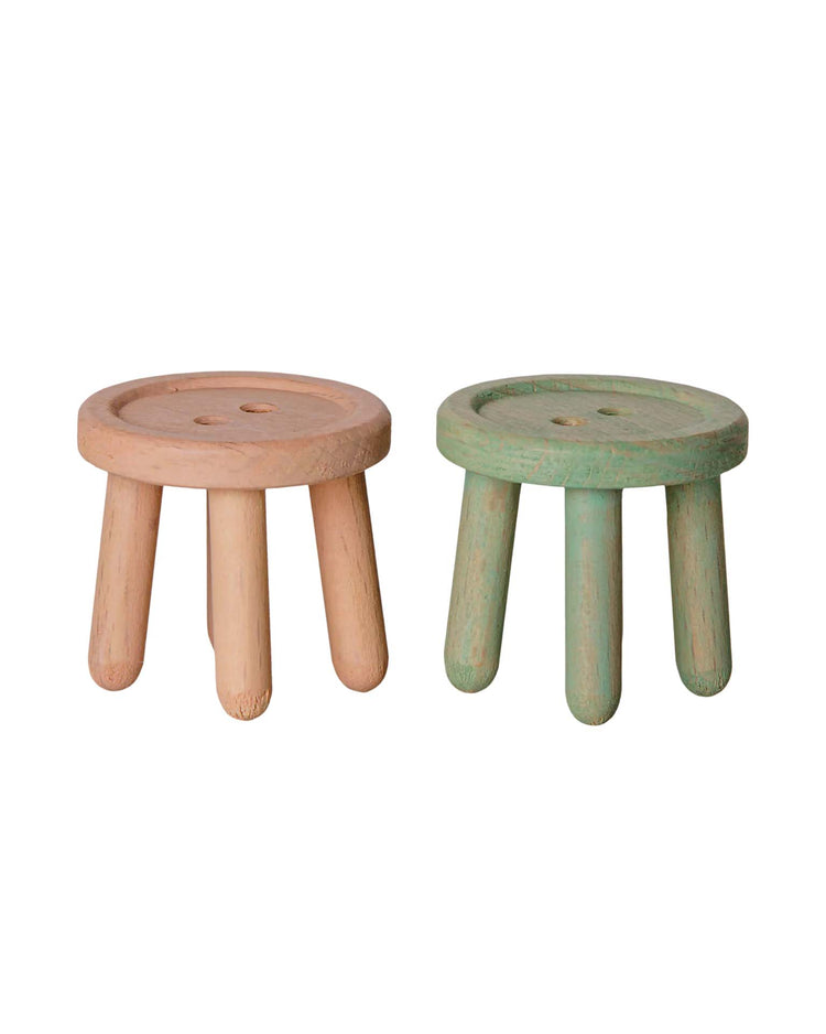 Two small, round, three-legged stools from maileg's "stool set, mouse - light rose/light mint" are side by side. One is painted a soft light rose and the other a gentle light mint. Both feature simple, minimalist designs and slightly textured finishes—perfect as mouse-sized stools for a wooden dollhouse or as charming accents in a Mouse Hole Farmhouse setting.