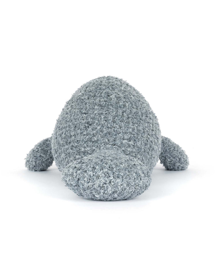 The jellycat maffles manatee, a plush gray toy with a textured, fuzzy surface, is shown lying on its belly and facing forward against a plain white background.