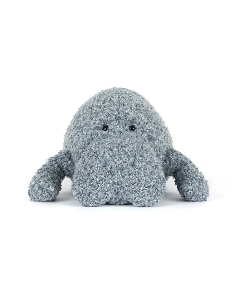 The jellycat maffles manatee is a plush gray toy with a soft, textured surface, lying flat with outstretched front fins and black bead eyes—an adorable addition to any collection.