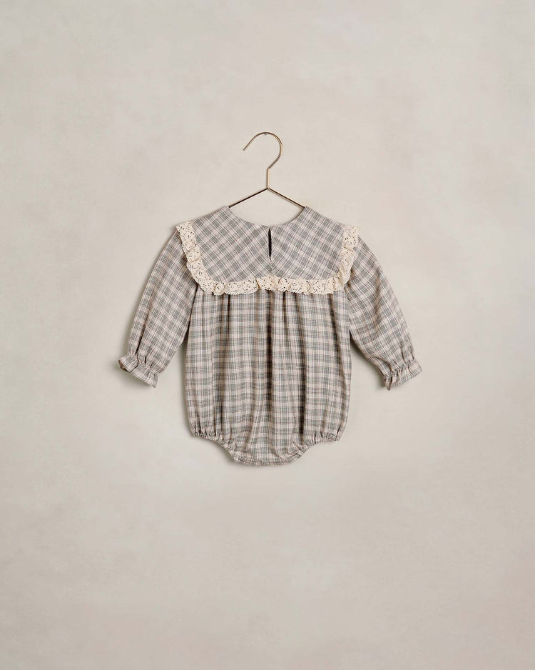 The noelle romper in fall plaid by noralee features long sleeves, a lace collar, gathered cuffs, and back buttons. Displayed on a hanger against a neutral background, this charming piece is perfect for cooler days and special occasions alike.