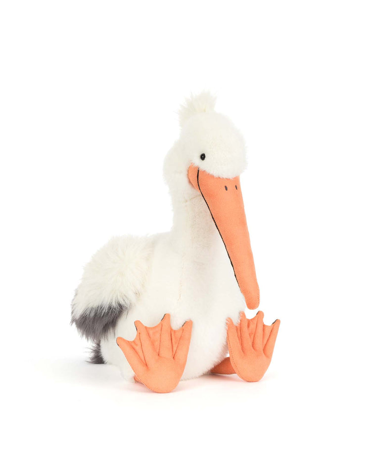 Keli pelican by jellycat features soft white fur, a long orange beak, orange webbed feet, and a fluffy tail—sitting upright with an adorable expression.