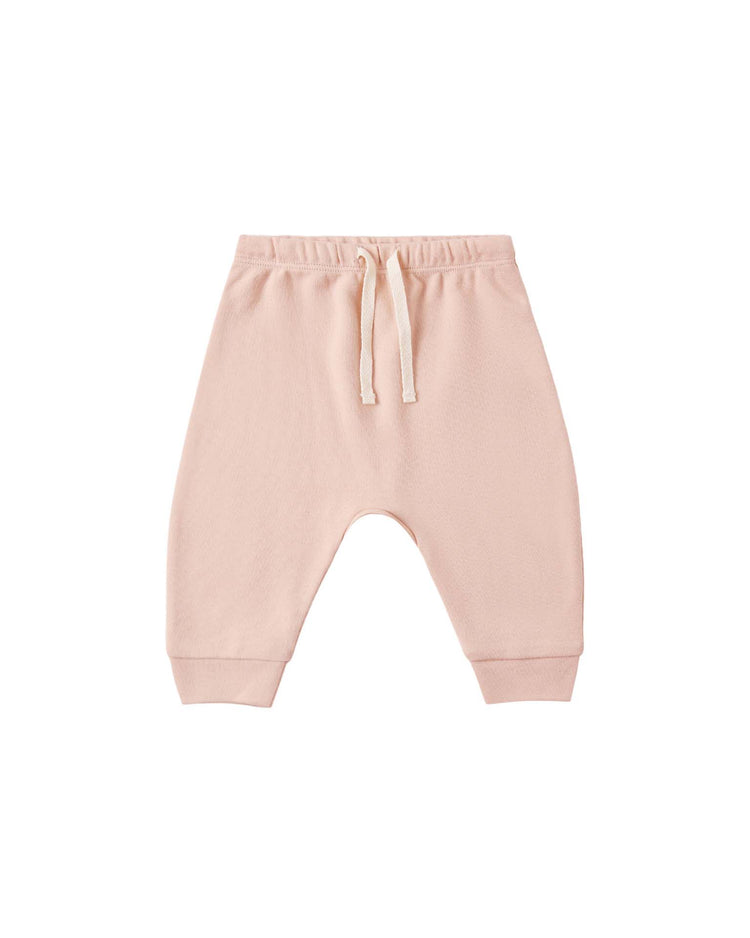 The "drawstring pant in dusty rose" by Quincy Mae features a light pink pull-on design with an elastic waistband, matching drawstring, and cuffed ankles, displayed on a white background.