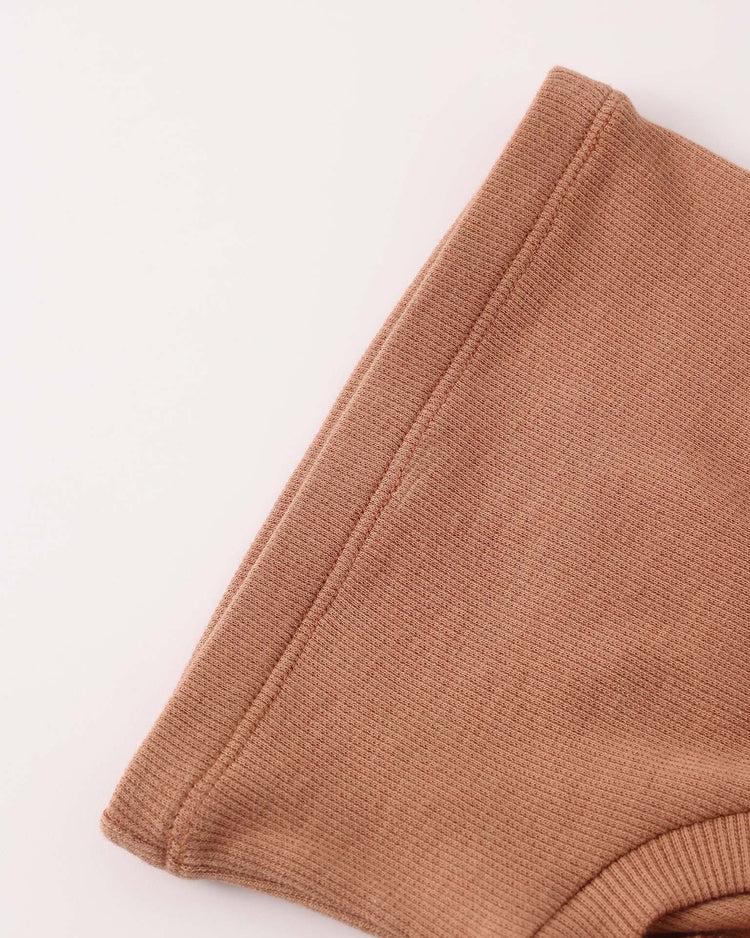 Close-up of the sleeve and shoulder of the ribbed tank dress in poppy by quincy mae, shown laid flat on a white surface.