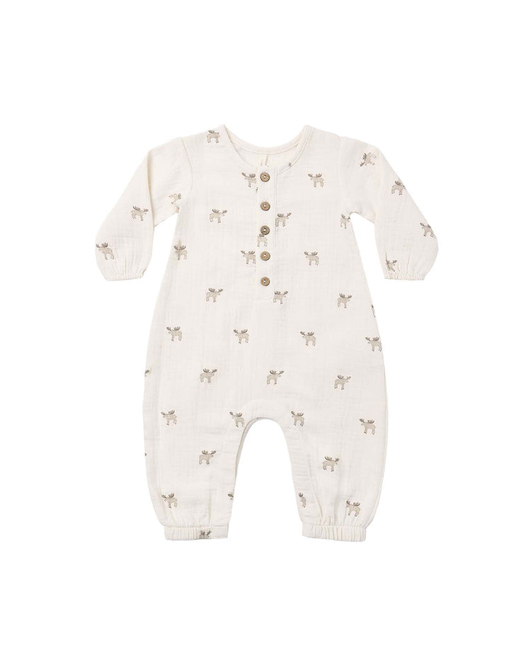 Introducing the "woven jumpsuit in moose" by quincy mae—a cream-colored, long sleeve baby jumpsuit crafted from cozy organic cotton. This stylish piece features convenient front buttons, an all-over light brown moose print, and elastic cuffs at the wrists and ankles for a comfortable fit.
