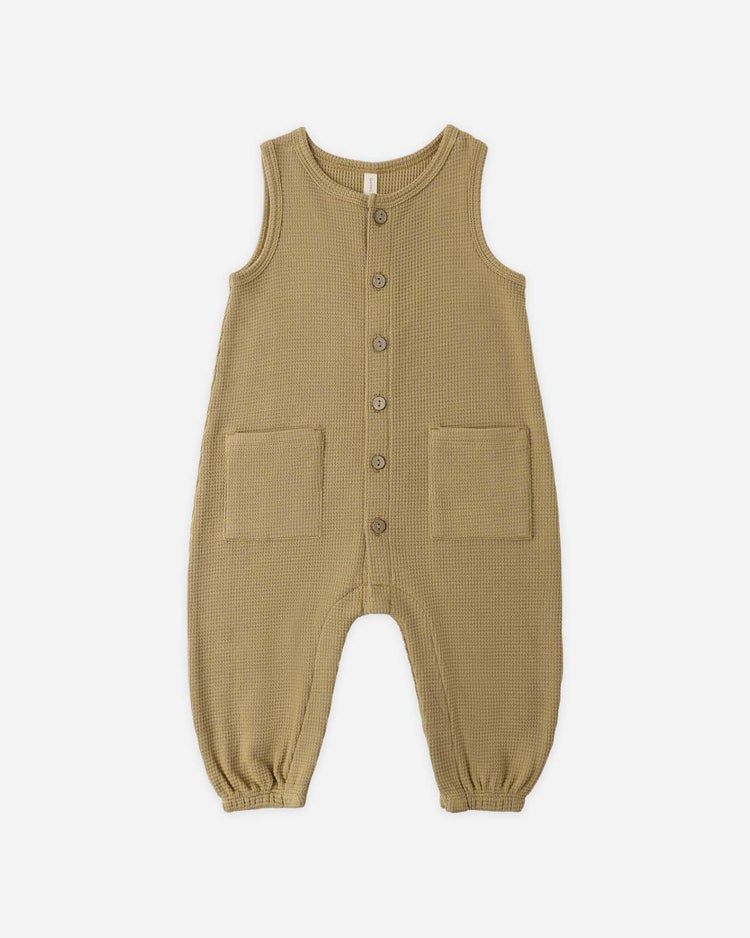 The quincy mae waffle jumpsuit in honey is a sleeveless, organic cotton baby outfit with front buttons, two large pockets, and elasticized ankle cuffs, shown on a white background.