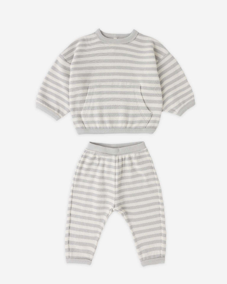 The quincy mae waffle sweater set in sky stripe is a two-piece toddler lounge set in soft organic cotton, featuring a long-sleeve top with front pocket and matching pants, both with ribbed cuffs and hems for comfort.