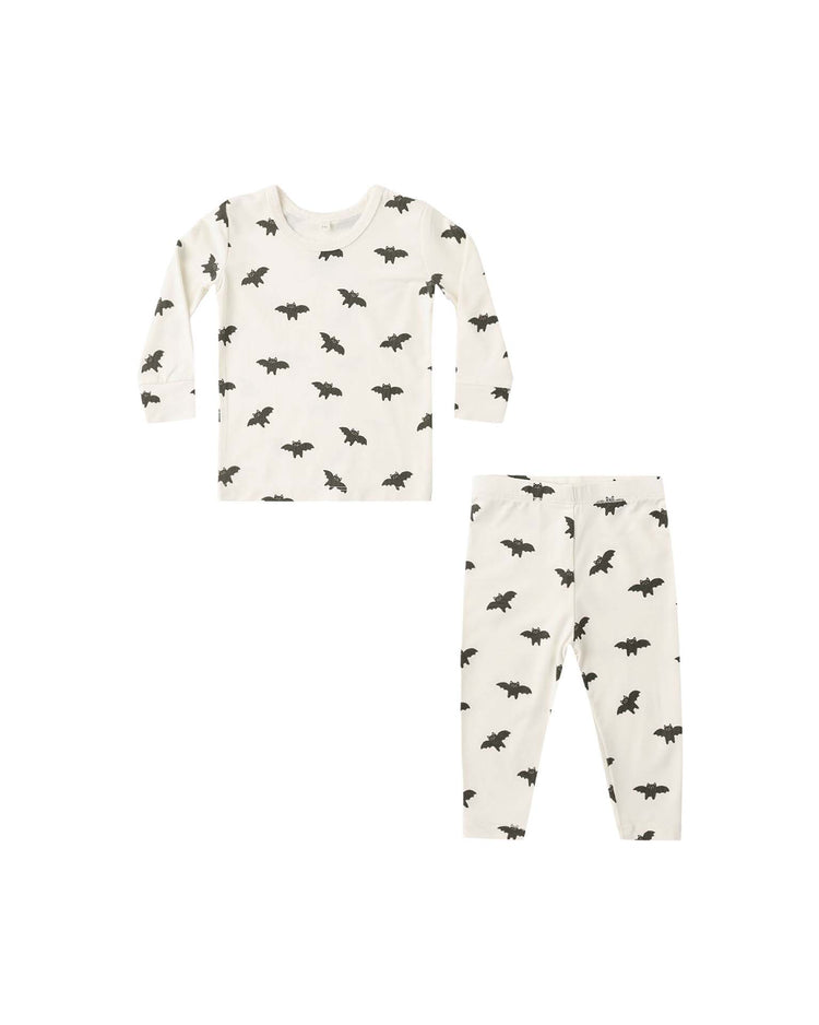 The quincy mae bamboo pajama set in bats is a white long-sleeve toddler pajama set featuring an allover black bat print and a slim-fit design for comfort and style. It includes a matching top and pants, shown on a white background.