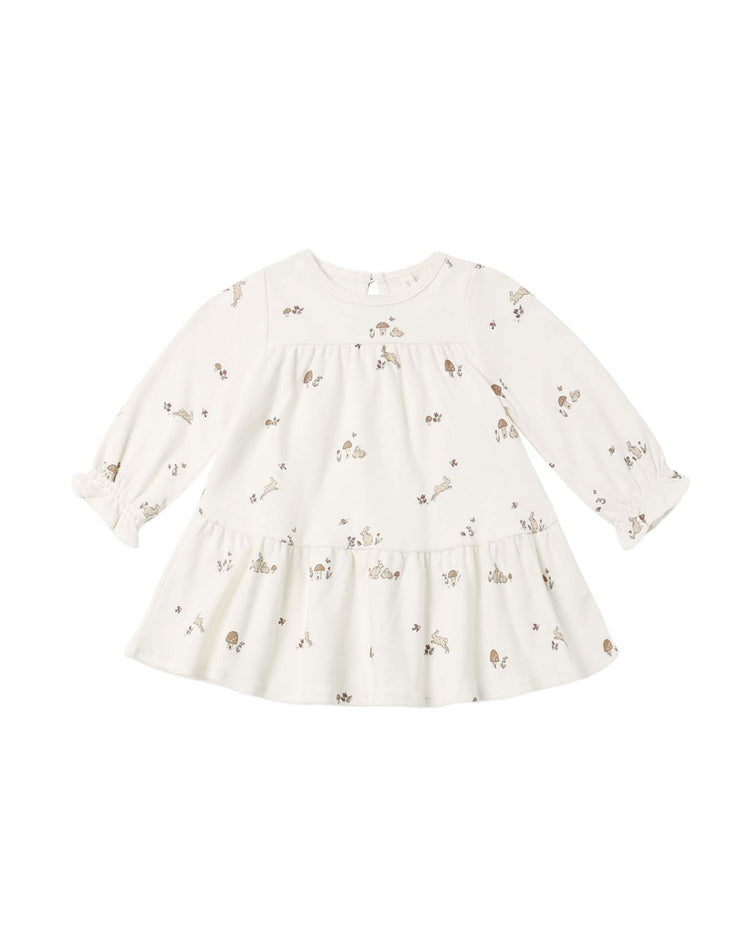 A long-sleeve, cream-colored "tiered jersey dress in bunnies" by quincy mae, crafted from soft organic cotton with a scattered bunny print, ruffled cuffs, and a gathered skirt. This charming long-sleeve dress is laid flat on a white background.
