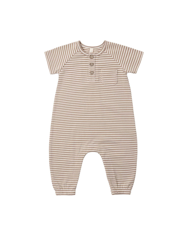 The "short sleeve jumpsuit in almond stripe" by quincy mae features beige and white horizontal stripes, three buttons at the chest, a small chest pocket, and elastic cuffs at the ankles. Made from organic cotton, this jumpsuit is shown laid flat on a white background.