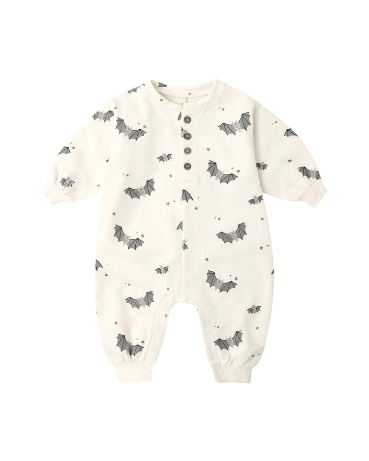 The relaxed fleece jumpsuit in baby bats by quincy mae is crafted from soft, organic cotton in a cream hue. It features long sleeves and an enchanting all-over baby bat print accented with tiny stars. Designed for cozy comfort, this jumpsuit offers a front button closure and elastic cuffs at the wrists and ankles.