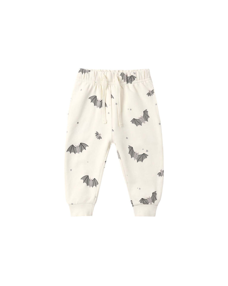 The “relaxed fleece sweatpant in baby bats” by quincy mae are white children’s jogger pants crafted from soft organic cotton fleece. They feature an elastic waistband, drawstring, and cuffed ankles for comfort. These cozy sweatpants showcase a playful baby bats print with small black bats and stars scattered across the fabric.