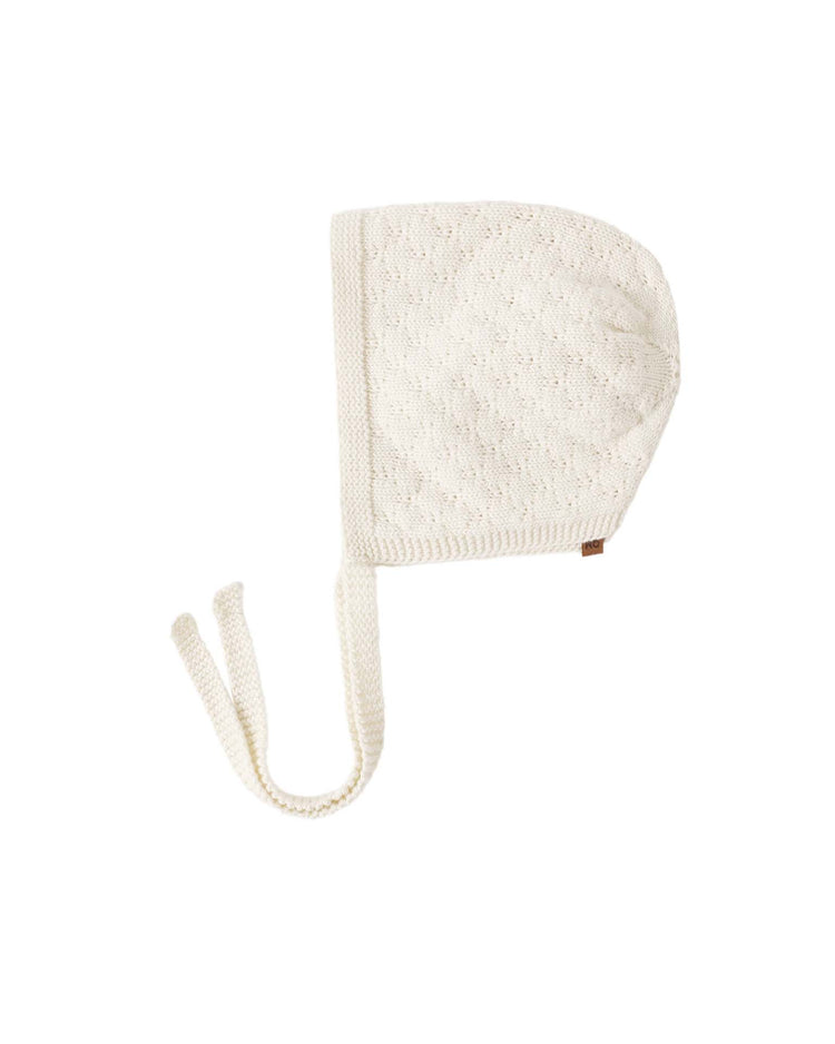 Quincy Mae's knit bonnet in natural, crafted from soft organic cotton with a subtle textured pattern and two long ties, is displayed flat against a white background.