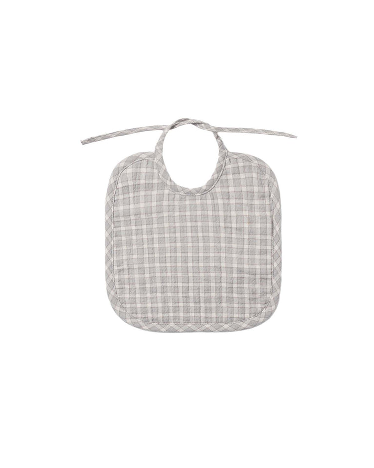A blue gingham woven tie bib by quincy mae, featuring a rounded shape and tie strings at the top, crafted from organic cotton for your baby's comfort, displayed on a plain white background.