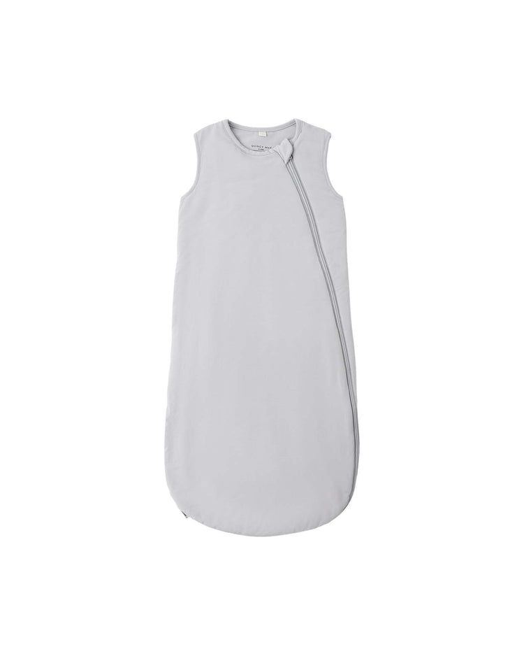 The bamboo sleep bag in cloud by quincy mae is a sleeveless, light gray baby sleep sack made from soft bamboo fabric. Featuring a simple, minimalistic design and a diagonal zipper running from the left shoulder to the right side, it offers a comfortable TOG rating of 1.0 for year-round use.