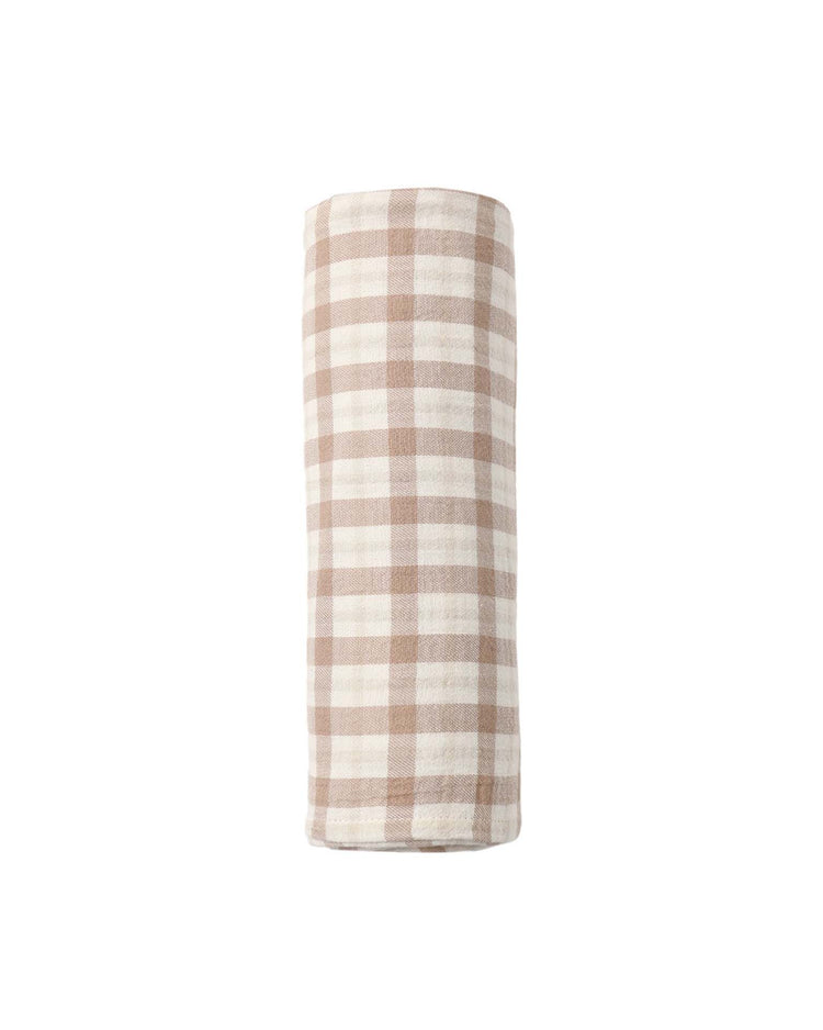 The quincy mae woven swaddle in rustic plaid—featuring a beige and white checkered pattern—appears rolled up against a plain white background.