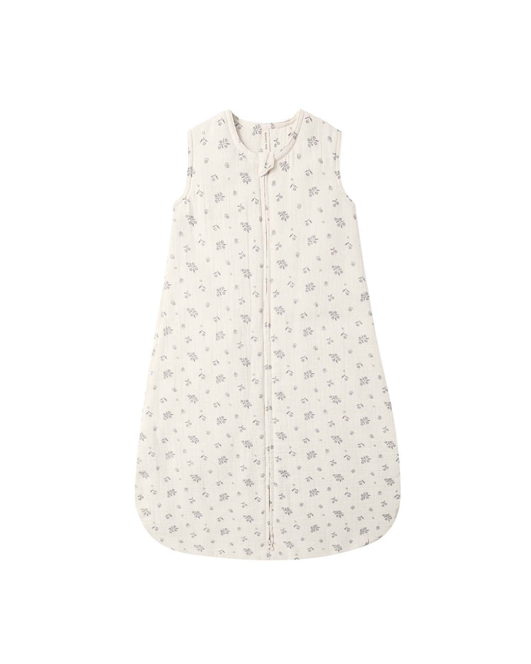 The Quincy Mae sleep bag in winter berry is a sleeveless baby sleep sack crafted from soft organic cotton, featuring a light beige background adorned with a delicate gray floral pattern and a convenient front zipper—perfect for cozy bedtime routines.