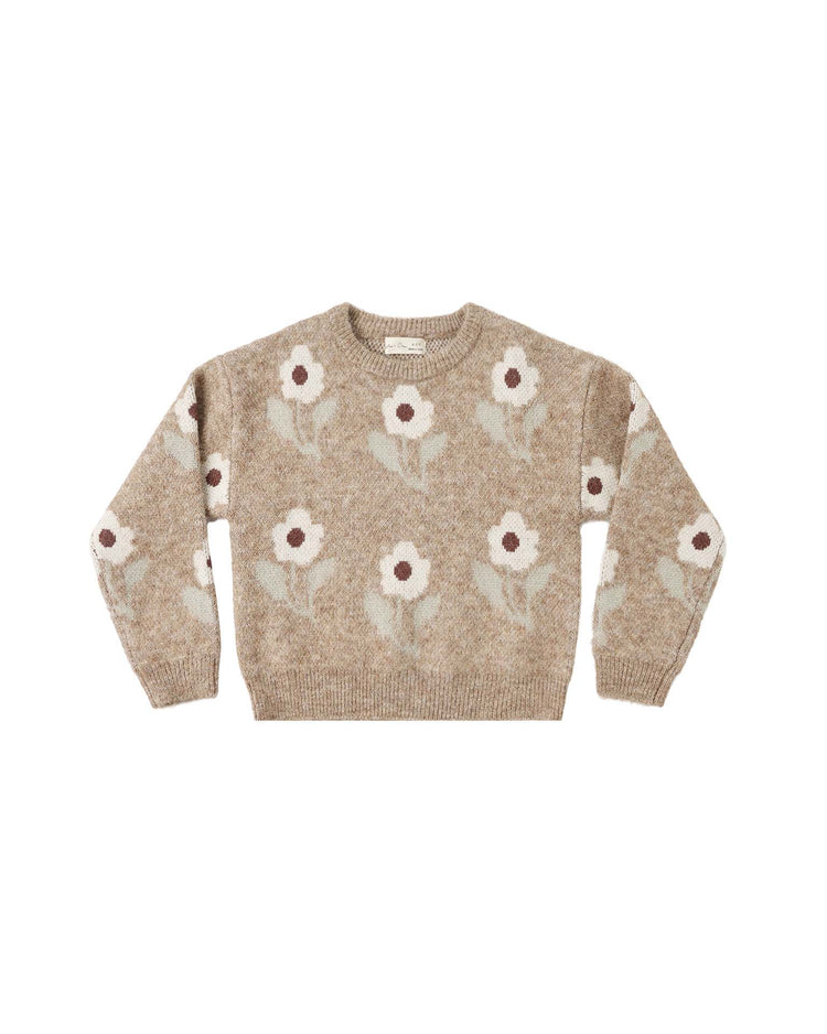 The aspen sweater in fawn flower by rylee + cru is a beige knitted crewneck with long sleeves, offering cozy comfort and featuring a delightful jacquard pattern of white flowers with brown centers and green stems scattered across the front, back, and sleeves.