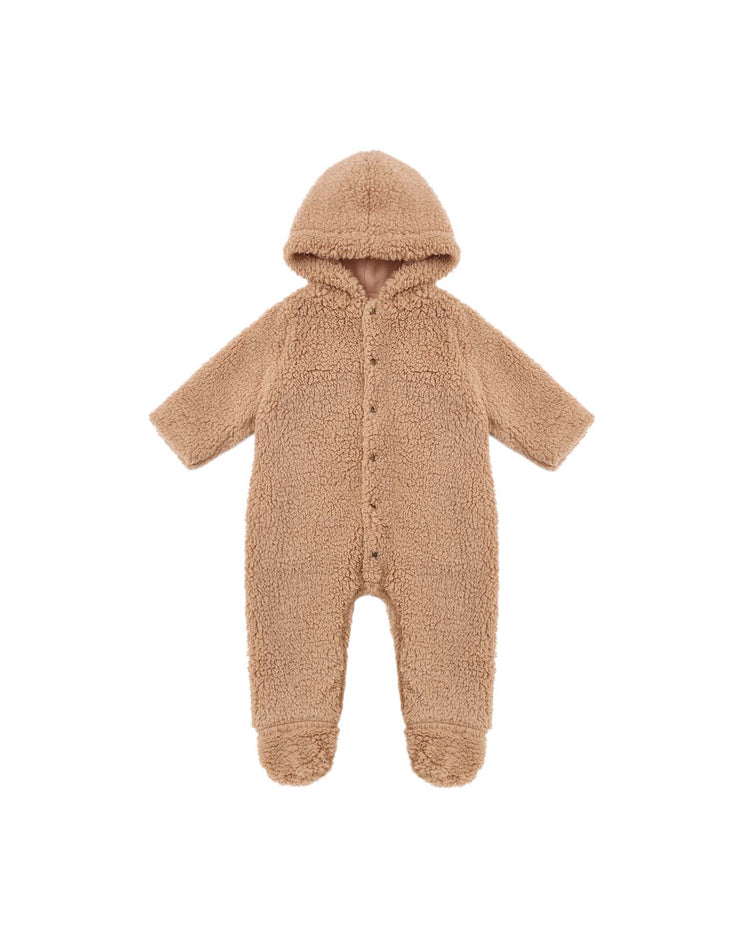 The “fleece jumpsuit in fawn” by rylee + cru is a tan, hooded baby onesie with long sleeves, crafted from soft, textured shearling fabric. Featuring covered feet and front snap buttons, it’s the perfect cozy layer to keep your little one warm.