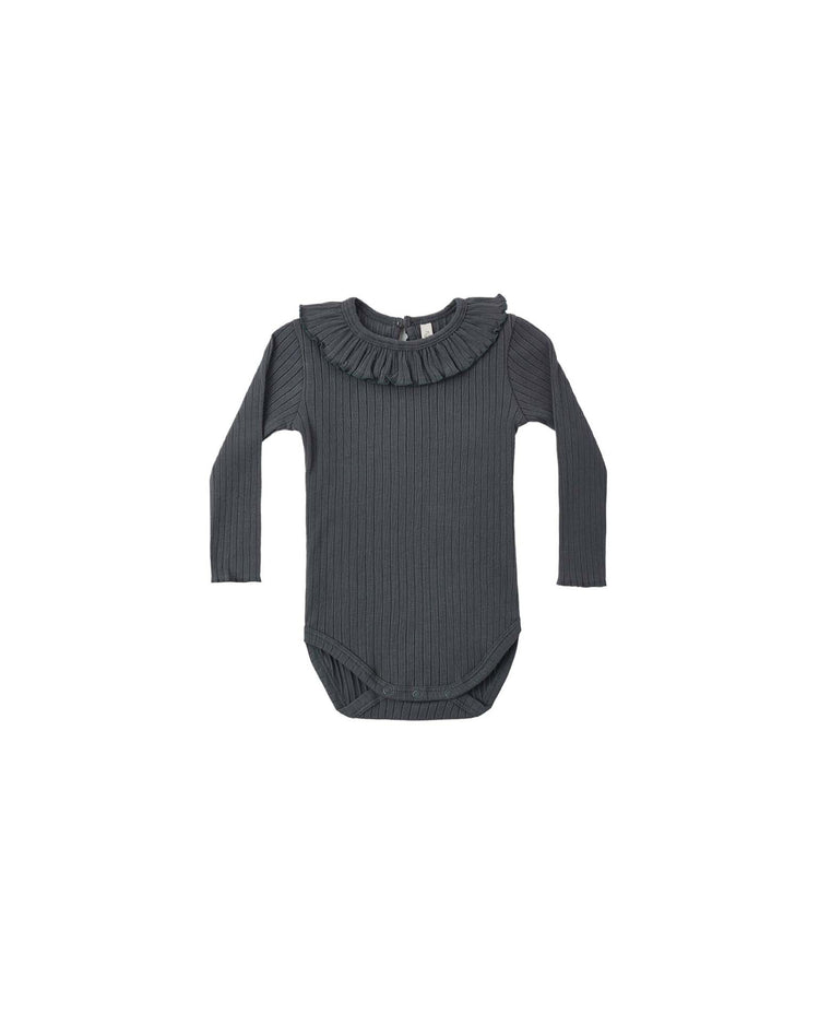 The PREORDER ruffle collar bodysuit in midnight by rylee + cru is a dark gray, ribbed knit baby bodysuit featuring a charming ruffle collar and long sleeves, displayed on a white background.