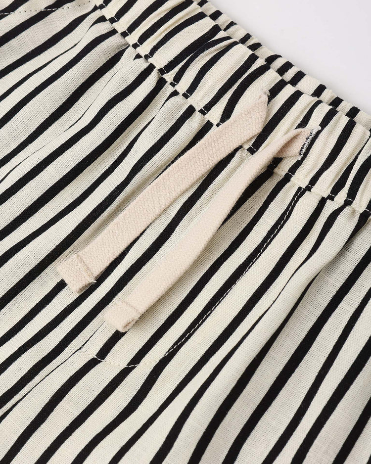 Close-up of the rylee + cru perry short in wavy stripe, featuring black and white vertical stripes, elastic waistband, beige drawstring, pockets, and a relaxed vintage linen look.