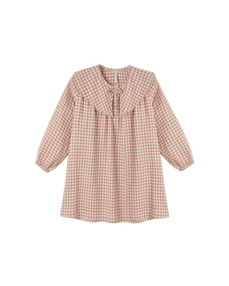 The collette mini dress in fawn gingham by rylee + cru is a 100% cotton, long-sleeve, knee-length dress in a charming pink and white gingham pattern, featuring a ruffled yoke, gathered cuffs, and a tie neckline.