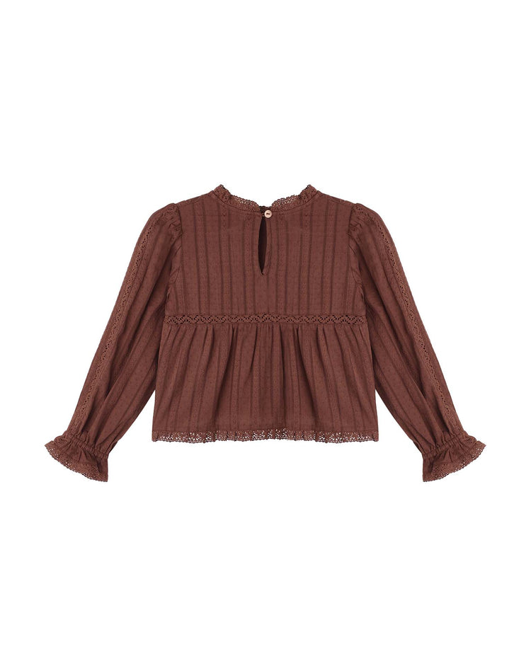 A long-sleeve Cecile Blouse in mulberry by rylee + cru, featuring delicate lace trim, a gathered waist, ruffled cuffs, and a small button keyhole closure at the back neckline, displayed on a white background. This cotton prairie top beautifully blends vintage-inspired charm with modern elegance.