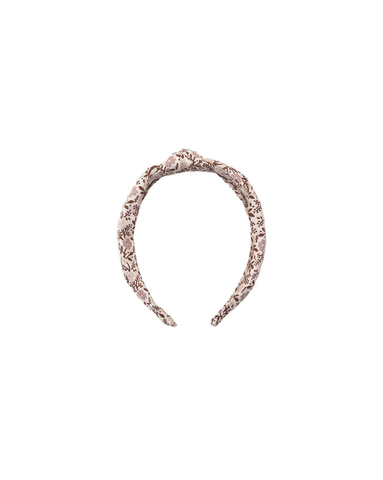 The rylee + cru knotted headband in primrose features a light pink cotton base adorned with a brown floral print, elegantly displayed on a white background.