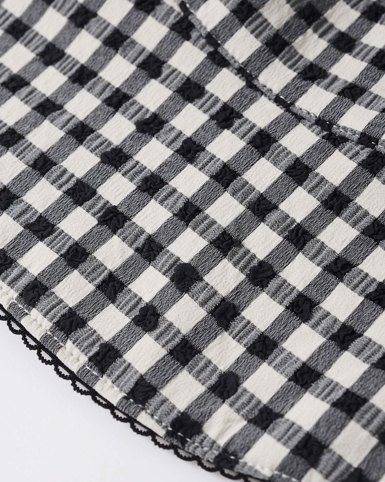 Close-up of the rylee + cru swim hat in black gingham, crafted from recycled polyester with a subtle dotted texture and delicate black lace trim, offering UPF 50+ protection for lasting style.