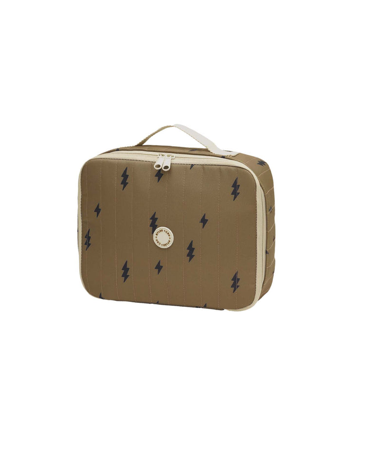 Introducing the "lunch bag in bolts" by rylee + cru—a tan zippered pouch featuring a white handle, bold black lightning bolt patterns, and a circular logo on the front. This stylish lunch bag combines flair and practicality for carrying your daily meals.