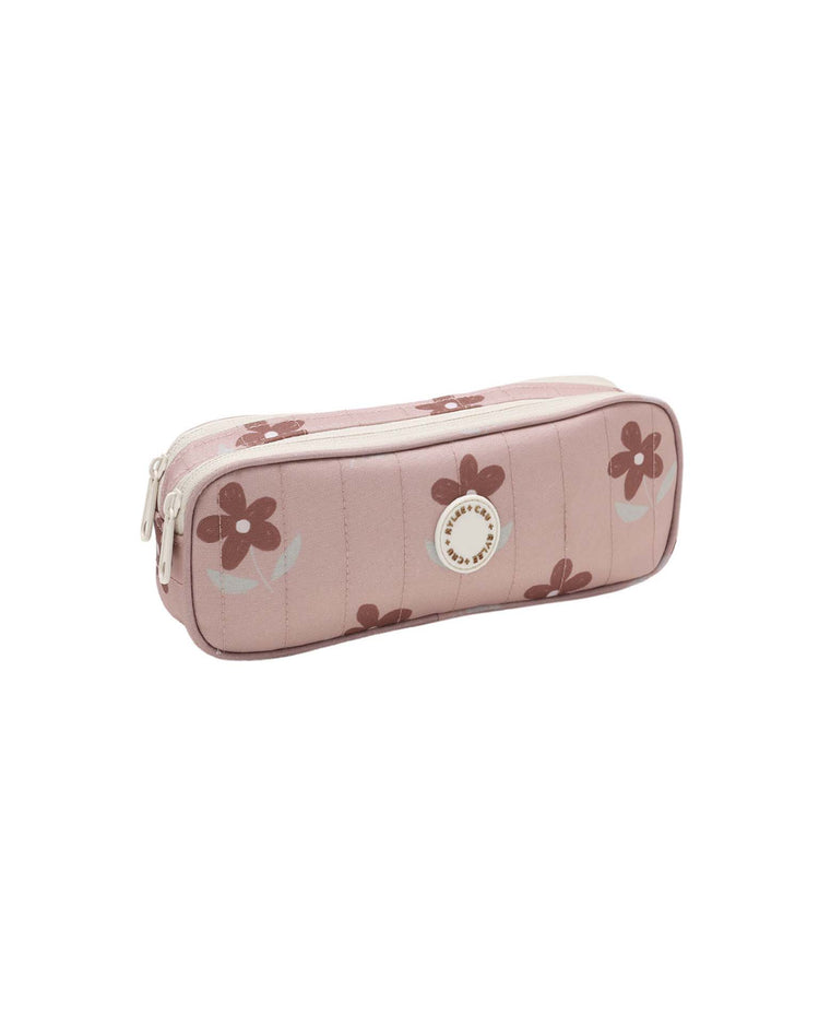 The "pencil pouch in little daisy" by rylee + cru features a light pink rectangular design adorned with charming brown daisy motifs and a white circular logo on the front, made from durable polyester and pictured at an angle against a white background—ideal for keeping school essentials organized.