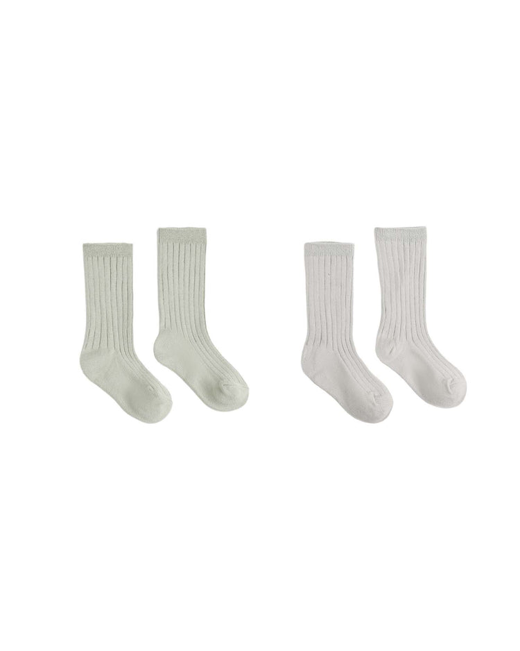 Two pairs of rylee + cru ribbed socks in “fog” and “sage” are displayed side by side on a white background.