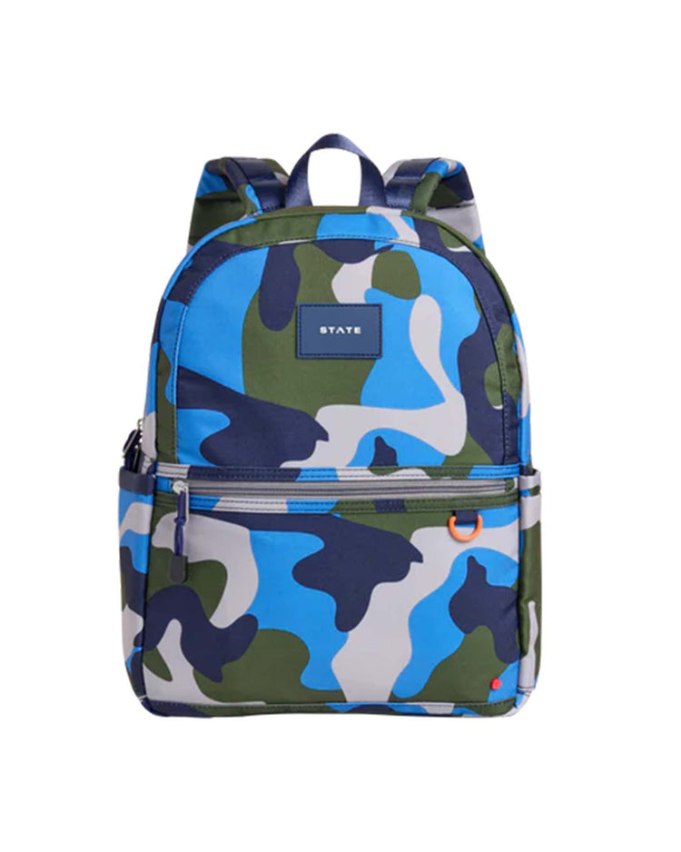 Introducing the Kane Backpack in Camo from STATE Bags—a stylish and functional travel backpack featuring a blue, green, black, and white camouflage pattern, a front zipper pocket, and the signature STATE label on the upper front.