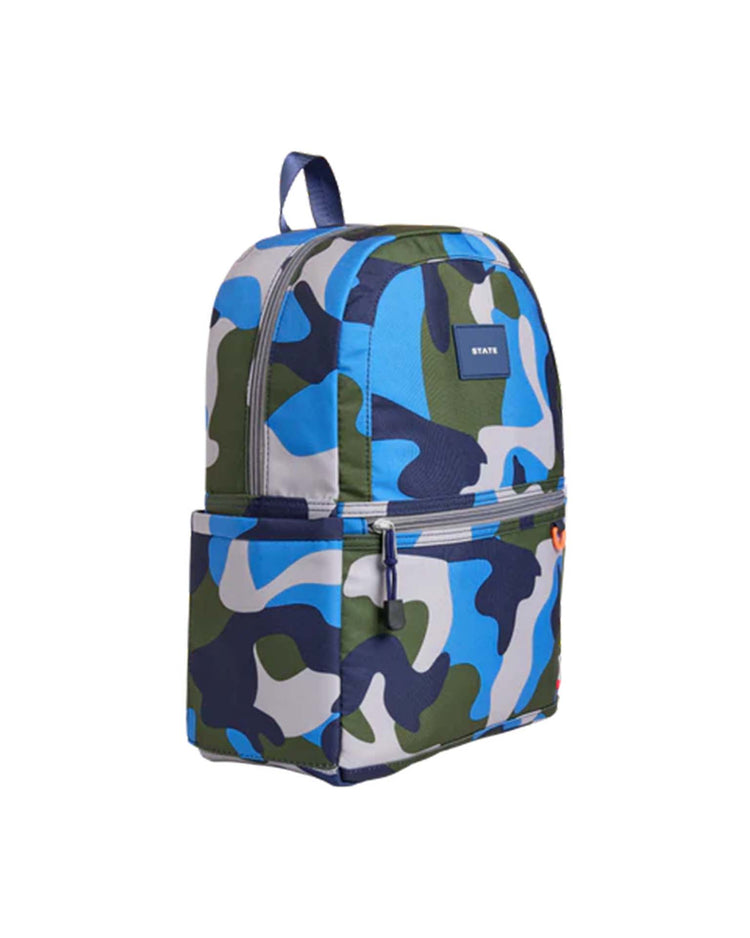 Discover the Kane Backpack in Camo by STATE Bags—a stylish blue, green, and white camouflage backpack featuring a front zipper pocket, a top handle, and blue zipper detailing. With a small black STATE Bags label on the front, this versatile bag is perfect for school or everyday adventures.