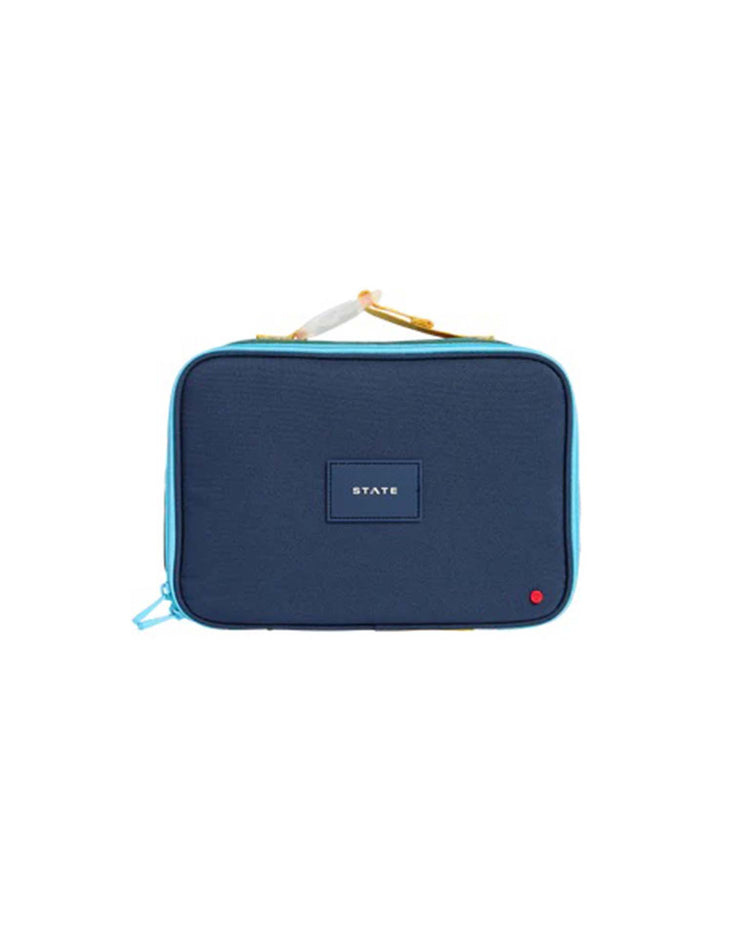 Green and navy rectangular insulated lunch box from STATE Bags, featuring light blue trim, a yellow handle, and a small red dot in the bottom right corner. Designed as a practical kids lunch box, it has a patch with the word "STATE" centered on the front. The style is known as the Rodgers Lunch Box in Green + Navy.