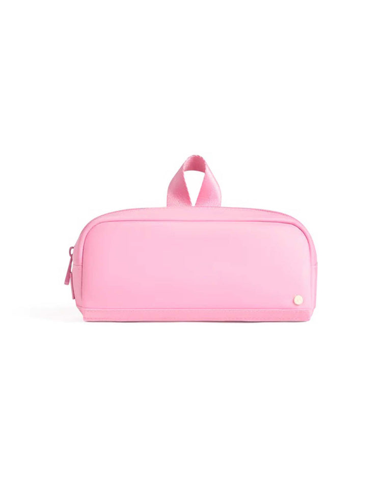 A rectangular pink Clinton Pencil Case by State Bags, featuring a zipper closure, a top handle, and a small round button detail in the bottom right corner, is displayed against a white background. This durable pencil case combines stylish design with practical functionality.