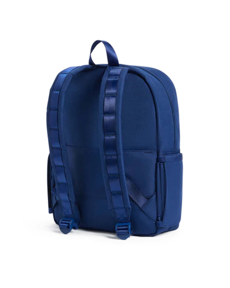 The Kane Backpack in Navy by STATE Bags is shown from the back, featuring padded shoulder straps, a top carrying handle, and side pockets. The travel backpack is displayed against a plain white background.